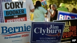 各路民主黨總統參選人的支持者在眾議院多數黨黨鞭吉姆·克萊伯恩主辦的一次活動的場外為豎立競選標牌。 (2019年6月21日)