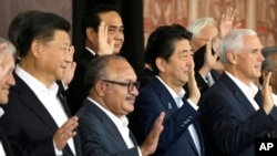 中国国家主席习近平（左）和美国副总统彭斯（右）在巴布亚新几内亚举行的亚太经合组织峰会领导人合影时同框。（2018年11月18日）