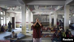 在加德满都，一名藏族妇女在同情西藏的暴力受害者和自焚抗议者的活动中祈祷 