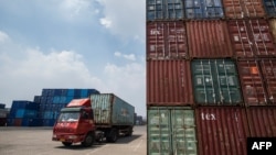 2018年8月7日，中国江苏省张家港港口堆放着集装箱，一辆卡车运输集装箱，在旁边开过。
