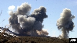 ຮູບພາບທີ່ບໍ່ຮູ້ວັນທີ ເຜີຍແຜ່ໂດຍ Army Times ວັນທີ 5 ມີນາ 2002 ສະແດງໃຫ້ເຫັນຄວັນໄຟພູ້ງຂຶ້ນ ຢູ່ທີ່ໜັ້ນຂອງຕາລິບານ ແລະອາລ-ຄາອິດາ ຢູ່ເທິງພູ Sirkankel ປະເທດອັຟການິສຖານ ຫລັງຈາກ ການຖິ້ລະເບີດຢ່າງໜັກຂອງ ສະຫະລັດ