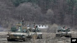 南韓軍人在坡州附近的年度軍演之際站在K-55自行榴彈砲上。（2016年3月7日）