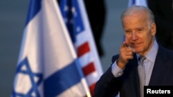 美国副总统拜登在飞机降落以色列本古里安国际机场后，向摄影师做出手势（2016年3月8日）