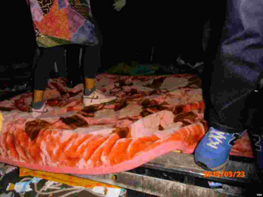 學生將棉被覆蓋在鐵刺障礙物上 (美國之音申華拍攝)