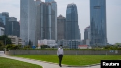 一名戴著口罩的男子行走在空空蕩蕩的香港金融區。 （2020年3月27日）