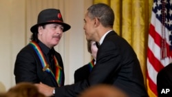 美國總統奧巴馬頒發肯尼迪中心終身成就獎予其中一名得獎者卡洛斯.桑塔納。