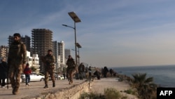 反政府武裝士兵2024年12月10日在敘利亞沿海城市拉塔基亞巡邏。