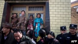 2018年3月1日，多名西藏兒童穿上傳統服裝慶祝西藏新年，旁邊有武警監視。