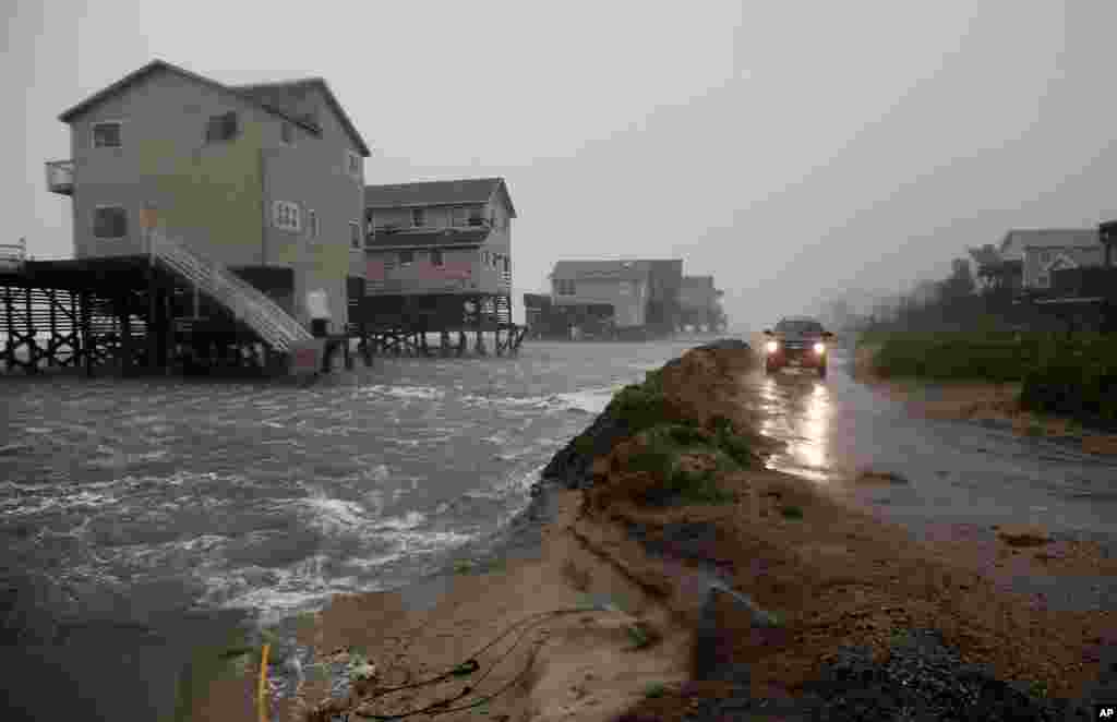 Abandoned beach front houses are surrounded by rising water as the effects of Hurricane Irene are felt in Nags Head, North Carolina. (AP Image)