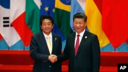 2016年9月，日本首相安倍晉三（左）在杭州參加G20峰會期間和中國國家主席習近平握手。