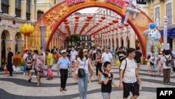 这张照片拍摄于2023年10月3日，显示中国游客在10月初为期一周的假期期间走过澳门的塞纳多广场。（法新社）