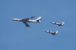 资料照：中国空军一架轰-6和两家歼-10战斗机在北京参加庆祝抗战胜利70周年纪念活动。（2015年9月3日）