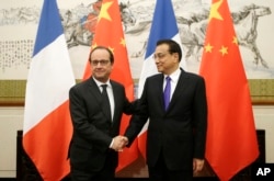 法国总统奥朗德和中国总理李克强北京举行的中法气候与绿色经济论坛握手。