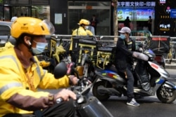 美團快遞的快遞員們正準備把一家北京餐館的午餐飯盒送出。（2021年4月27日）