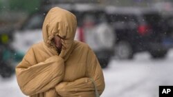 一位婦女在暴風雪中的北京街道上行走。