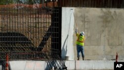 资料照片：一名建筑工人为德克萨斯州米逊的一段边界墙涂漆。(2020年11月16日)