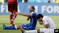 烏拉圭球員蘇亞雷斯 (右)與意大利防守隊員齊埃利尼 (左)相互推擠後倒地