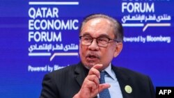 ນາຍົກລັດຖະມົນຕີ ອັນວາ ອິບຣາຮິມ ຂອງມາເລເຊຍ ກ່າວໃນລະຫວ່າງກອງປະຊຸມສົນທະນາ ດ້ານເສດຖະກິດ ກາຕ້າ ໃນ ໂດຮາ ວັນທີ 14 ພຶດສະພາ 2024. (ຮູບພາບໂດຍ ກາຣິມ ຈາຟາ/ອົງການຂ່າວ ເອເອັຟພີ).