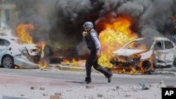 2021年5月11日以色列消防員在被導彈擊中的汽車旁。