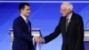 FILE - Democratic presidential candidates Pete Buttigieg, left, and Bernie Sanders shake hands on stage, Feb. 7, 2020, before the start of a Democratic presidential primary debate at Saint Anselm College in Manchester, N.H.