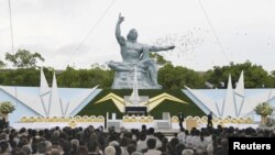 日本长崎的和平公园纪念原子弹轰炸72周年，鸽子在和平雕塑上空飞过（2017年8月9日）