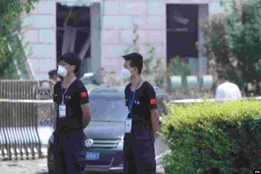 天津爆炸事故现场，核心爆炸区周围多座居民楼窗户被震碎，高速公路桥梁受损，多辆大货车被炸翻，小汽车起火或被砸，多名当地居民仍逗留在事故现场。（美国之音记者东方拍摄）