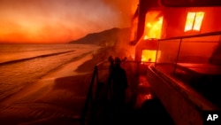 资料照片：洛杉矶马利布地区的消防员正在努力扑救一栋燃烧的海滨建筑。(2025年1月8日)