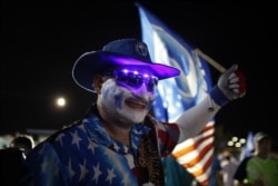 FILE - A pro-statehood New Progressive Party supporter waves his party's flag a campaign rally in San Juan, Puerto Rico, Nov. 3, 2012.