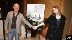 在演员艾玛·斯通主持的电影《聚焦》的特别观影活动里，她和演员迈克尔·基顿。这个影片的制片和发行公司是开路电影公司