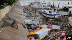 Allen Heath surveys the damage to a private marina after it was hit by Hurricane Hanna, July 26, 2020, in Corpus Christi, Texas. Heath's boat and about 30 others were lost or damaged.