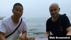 姜建軍（左）、王承剛在大連老虎灘海邊祭奠兩天前海葬於附近海域的劉曉波。（2017年7月17日推特圖片）