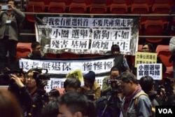 示威者在記者會舉行期間在座位上掛起抗議棋額。（美國之音湯惠芸攝）