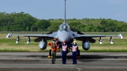 台湾空军人员在一架完成升级的F-16V战机交付仪式上敬礼。（2021年11月18日）