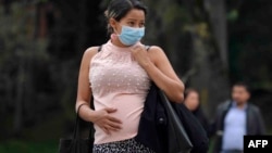 2020年3月16日哥倫比亞波哥大：戴口罩孕婦在等車。