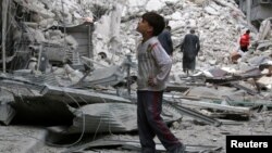 (資料照片：阿勒頗反政府力量控制區一個男孩凝視著空襲後的廢墟)