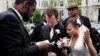 Bishop Harry R. Jackson Jr. of Beltsville, Md., left, prays with Jonathan Paul Ganucheau, 24, and Denise Buckbinder Ganucheau, 26, both of Dallas, Texas, before performing a religious wedding ceremony in Washington, May 5, 2009. 