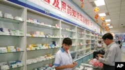 中国北京，一名工作人员在药店为顾客服务（2004年9月29日）。