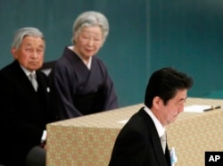 日本首相安倍晋三在日本武道馆举行的纪念战争亡灵活动中发表讲话后，走过天皇明仁和皇后美智子的身边。（2018年8月15日）