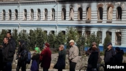 在新近被收复的乌克兰城镇伊久姆，当地居民排队领取人道救援物资。(2022年9月26日)
