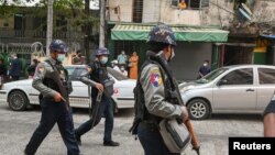 警察持槍走在甘馬育鎮法院外，法院正在就抗議期間被拘捕的一組記者舉行聽證。 (2021年3月12日)