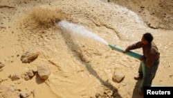 一名中國工人2011年1月16日在江西省南城縣的一個稀土礦里工作。