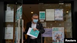 一名香港市民離開新冠疫苗接種中心（路透社照片）