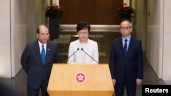 香港特首林鄭月娥在記者會上講話時，署理行政長官張建宗（左）站在她身旁。（2019年9月5日） 