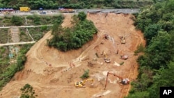 ພາບຖ່າຍທາງອາກາດ ທີ່ຖືກຖ່າຍໃນວັນທີ 2 ພຶດສະພາ, ສະແດງໃຫ້ເຫັນບັນດາຜູ້ກູ້ໄພ ແລະ ລົດຈົກ ພາກັນປະຕິບັດງານຢູ່ໃນຂົງເຂດທາງຫຼວງທີ່ພັງຍຸບລົງມາ ເທິງທາງດ່ວນ Meizhou-Dabu Expressway ໃນເມືອງເໝີຍຊູ (Meizhou), ປະເທດຈີນ. (Xinhua News Agency via AP)