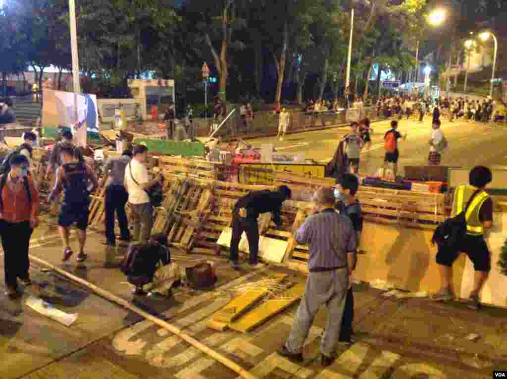 数以百计占中支持者在金钟道从中银大厦至警察总部长达150的路段上加固多处路障 (美国之音海彦 拍摄)