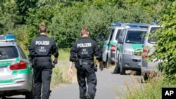 2016年7月19日，德国警察在挥刀杀人案件发生的现场巡逻。