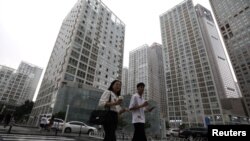 2021 年7 月13 日，人們走過中國北京中央商務區(CBD) 的辦公樓。