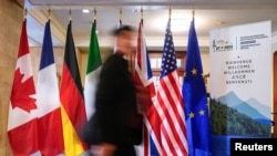 2025年3月12日，在加拿大魁北克省拉馬爾貝舉行的七國集團外交部長會議之前，一名男子在黎塞留莊園走過七國集團成員國的國旗。