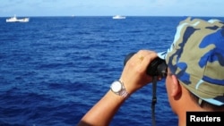 一名越南海警船成員在有爭議的南中國海上觀察中國海警船。（2014年7月15日）