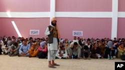 在加茲尼市，一名塔利班武裝人員看守著投降的阿富汗安全部隊成員。 (2021年8月13日)